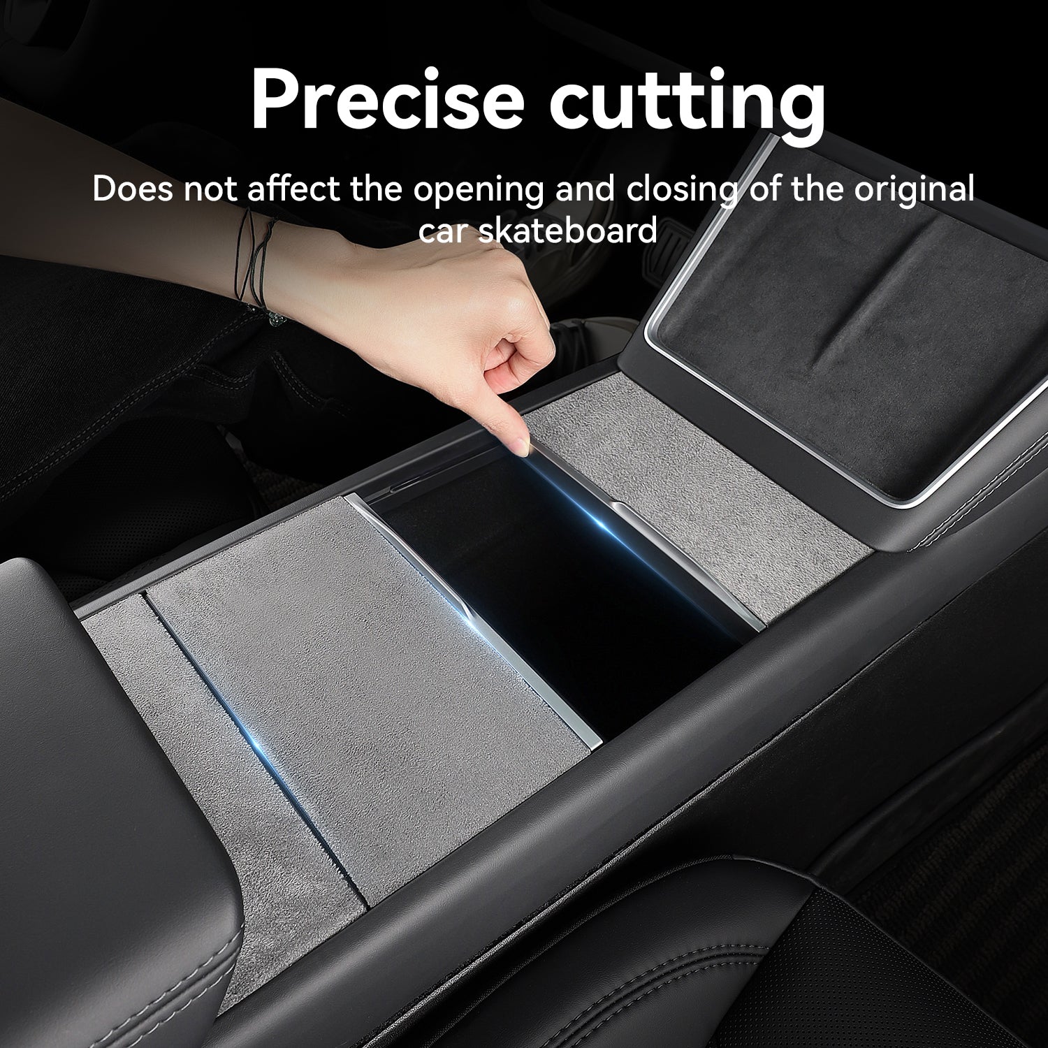 A hand demonstrates the precise cutting of a grey suede center console wrap on a Tesla, showing how the custom-fit protector allows the sliding cover to open and close smoothly without obstruction.